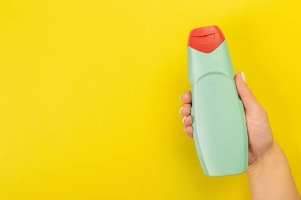 istock Cleaner's hand holding a  chemical spray bottle. Empty space for text or logo on a yellow background. Early spring or regular cleaning. Cleaning and cleaning concept. 1398786806