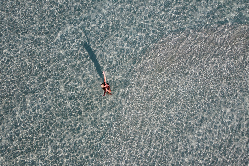 Attractive woman greetings from water. Aerial view.