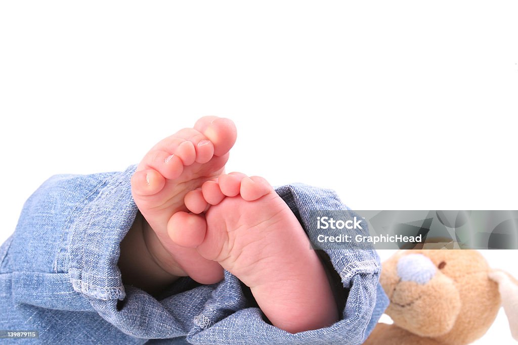 Baby Feet Baby feet in denim jeans from bottom with bunny looking on. Isolated on white and contains clipping path. Ankle Stock Photo