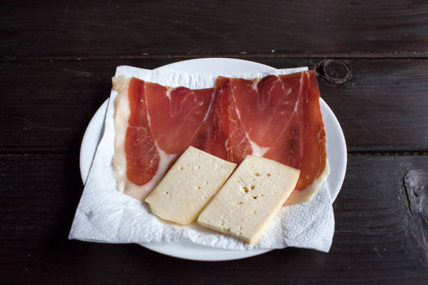 Sliced ham (pork meat), fresh from the butcher packed in a piece of white paper.