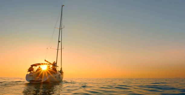 Medium group of friends sailing and having fun on boat during sunset.