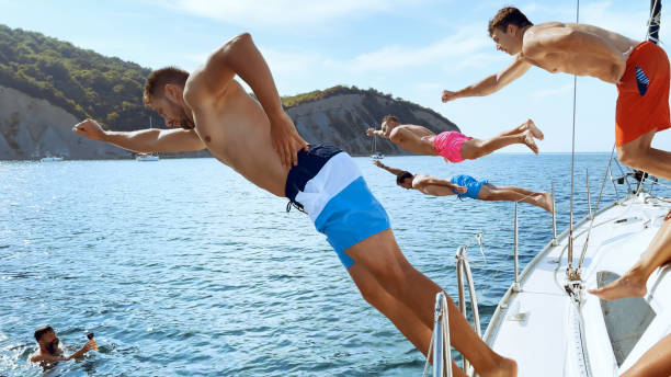 istock Friends jumping in sea 1398793553