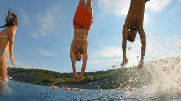 istock Friends jumping in sea 1398793585