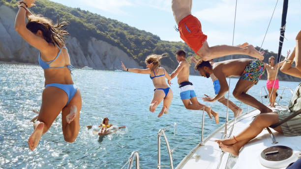 istock Friends jumping in sea 1398793586
