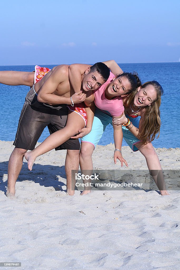 Adolescentes mixto de diversión en la playa divirtiéndose en vacaciones de primavera - Foto de stock de 16-17 años libre de derechos