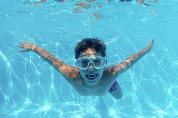 little kid diving into a swimming pool - swimming child swimwear little boys imagens e fotografias de stock