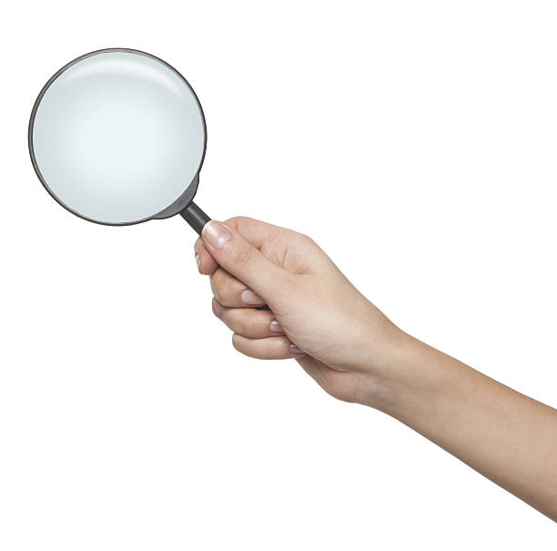 Magnifying glass in female hand stock photo