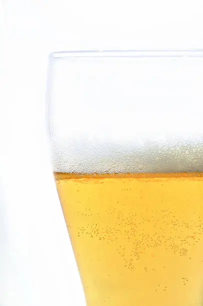 beer in glass isolated on white with bubbles and foam
