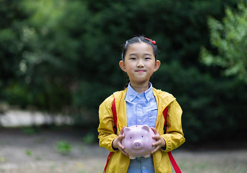 Little Asian Girl Holding Piggy Bank