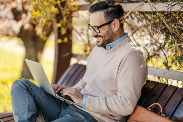 istock A man sits in a park and using laptop. 1398799665