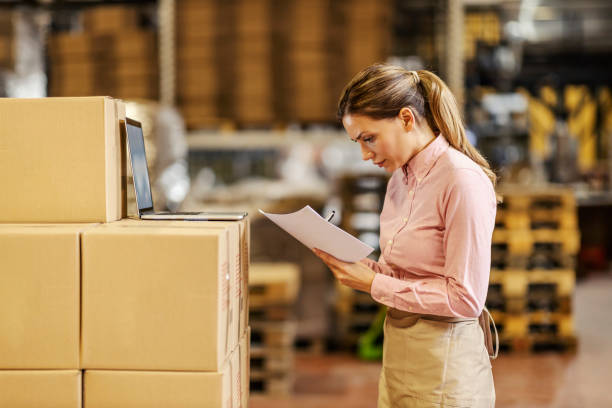 istock A female warehouse worker doing paperwork and controlling shipment. 1398801378