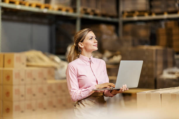 a food industry worker checking on shipment on the laptop in warehouse. - freight transportation warehouse manufacturing shipping imagens e fotografias de stock