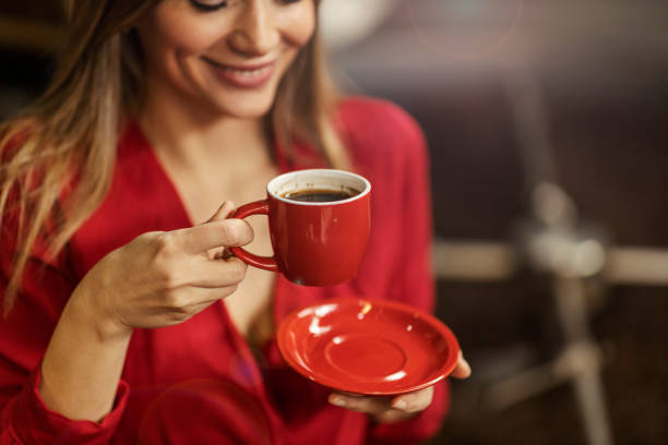 istock A happy woman enjoying cup of coffee while standing next to a coffee roasting machine. 1398802139
