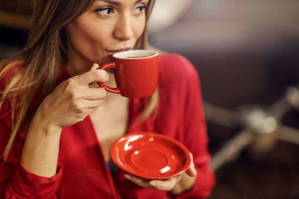 A woman drinking fresh coffee in coffee factory.