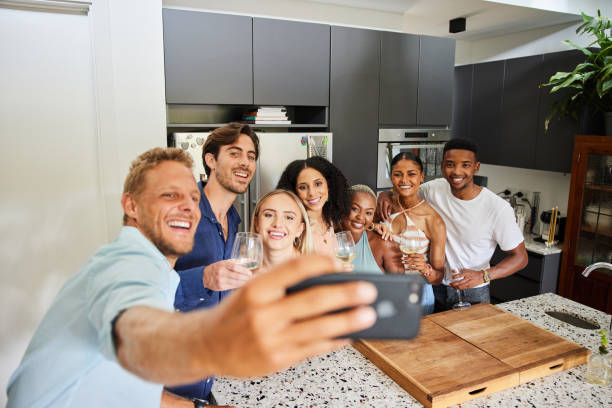 istock Diverse friends smiling and talking selfies together in a kitchen 1398803777