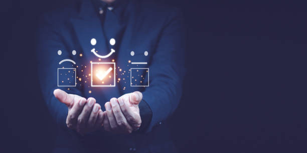istock Customer service evaluation concept. smiling Asian male Is using a smartphone And he is pressing face symbol smile in satisfaction on virtual touch screen. 1398804004