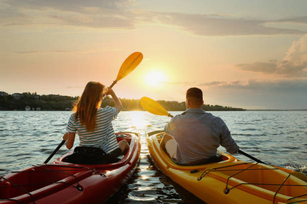 istock Couple kayaking on river at sunset, back view. Summer activity 1398804219