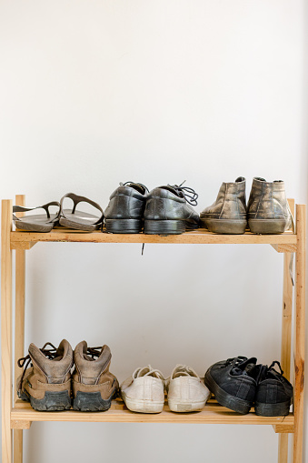 wooden shoe rack with old shoes