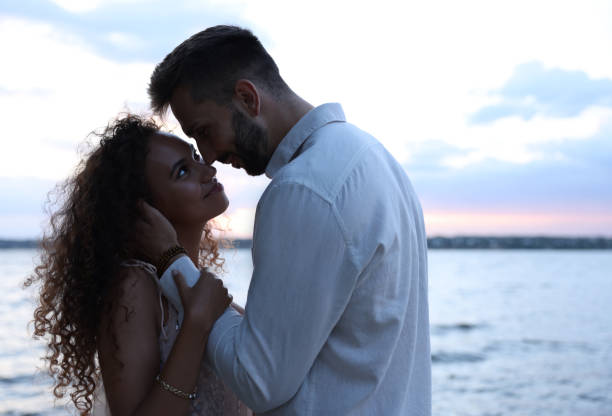 istock Lovely couple spending time together near river at sunset 1398805375