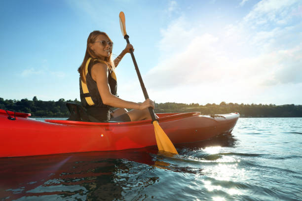 istock Happy woman in life jacket kayaking on river. Summer activity 1398805385