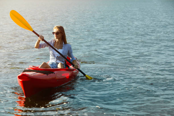 istock Beautiful woman kayaking on river, space for text. Summer activity 1398805398