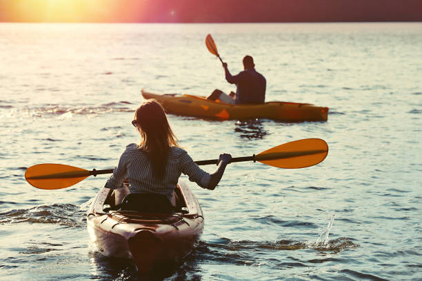 istock Couple kayaking on river in evening, back view. Summer activity 1398805409