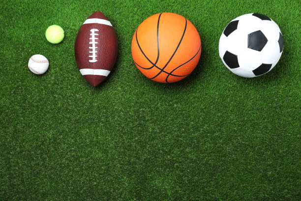 Set of different sport balls on green grass, flat lay. Space for text