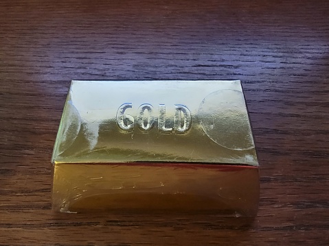 gold bars or blocks on wood desk or surface or table