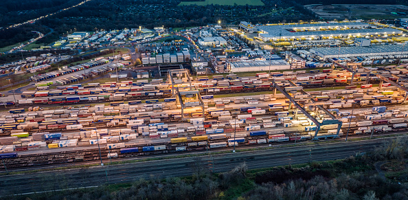 Aerial view of freight trains with cargo containers in a freight yard.