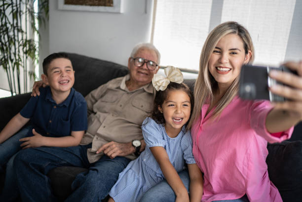 istock Multi generation family taking selfies or doing a video call using mobile phone at home 1398807188