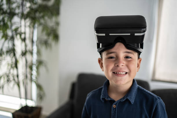 Portrait of boy playing with virtual reality simulator at home