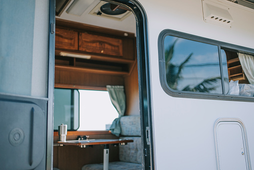 looking through door inside of motorhome with table and sofa backseat beside window