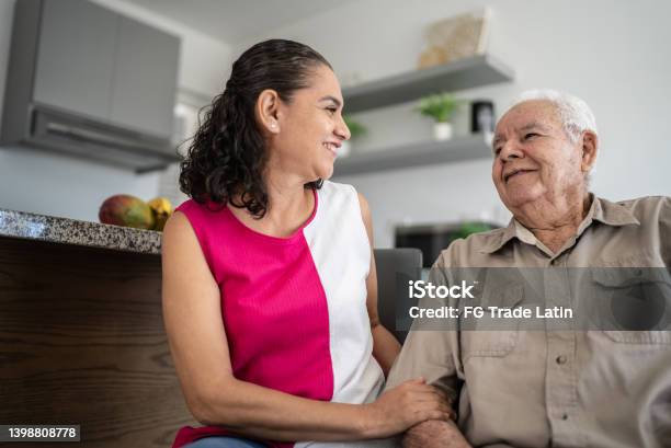Senior Man And His Daughter Talking At Home Stock Photo - Download Image Now