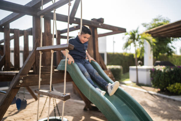 istock Boy playing on a slide outdoors 1398808942