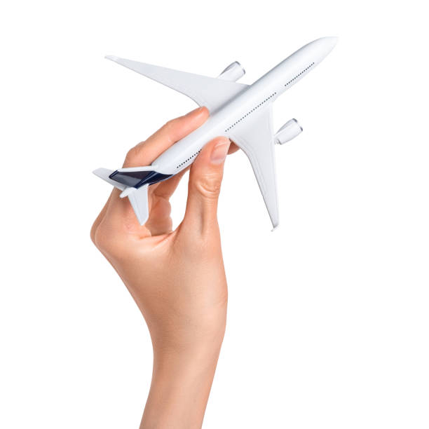 istock Hand holding airplane isolated over white background. 1398810135