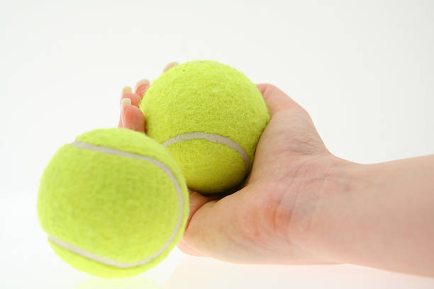 istock hand with two tennis balls 139881069