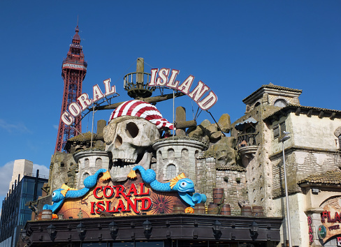Blackpool, Lancashire, United Kingdom - 5 March 2022: pirate themed sign above the coral island fun park and casino in blackpool with the tower in the background