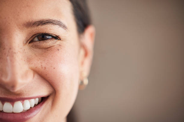 face of beautiful mixed race woman smiling with white teeth. portrait of a woman's face with brown eyes and freckles posing with copy-space. dental health and oral hygiene - närbild bildbanksfoton och bilder