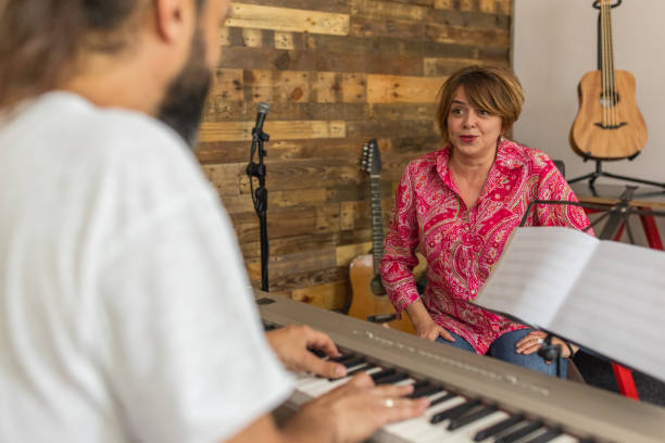 istock Woman singing, while music teacher playing synthesizer 1398811970