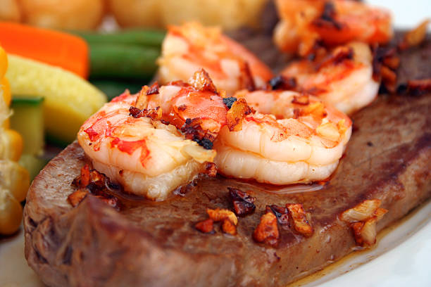surf and turf - surf and turf prepared shrimp seafood steak photos et images de collection