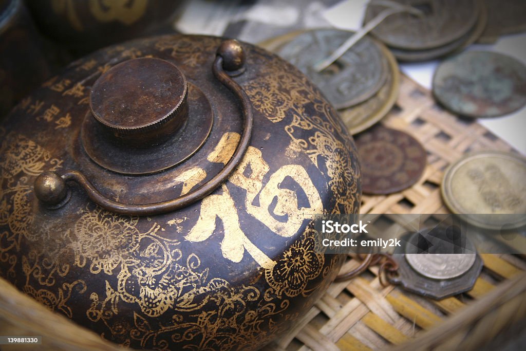 Ancient Oriental Vintage Chinese teapot and coins.  The golden Chinese word on the pot means â€œgood fortuneâ€ and â€œluckyâ€. Ming Stock Photo