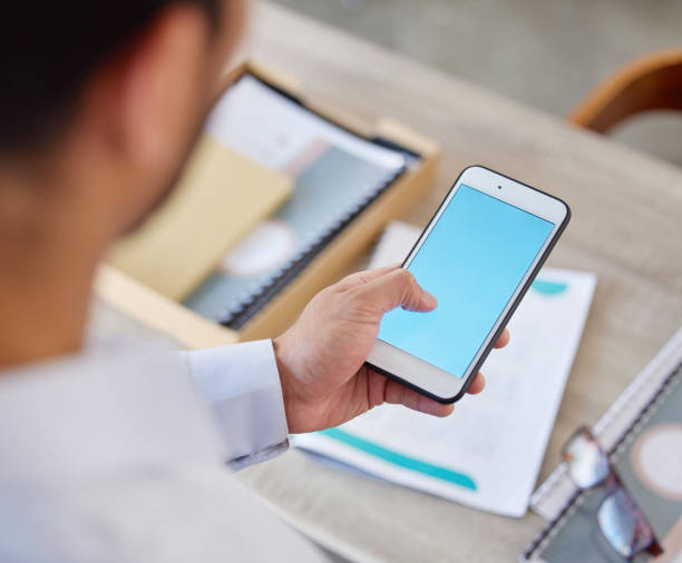 istock Unknown businessman browsing the internet on a cellphone in an office. Mixed race professional standing alone and scrolling through schedule and social network. Connecting with clients on technology 1398813968
