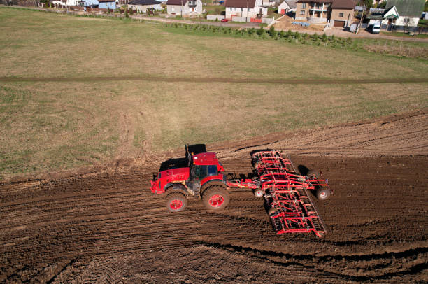 istock Tractor disk harrow on ploughing a soil. Sowing seed on plowed field on sunset. Seeding in agriculture. 1398814399