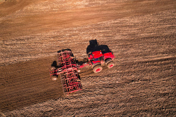 istock Tractor disk harrow on ploughing a soil. Sowing seed on plowed field on sunset. Seeding in agriculture. 1398815266
