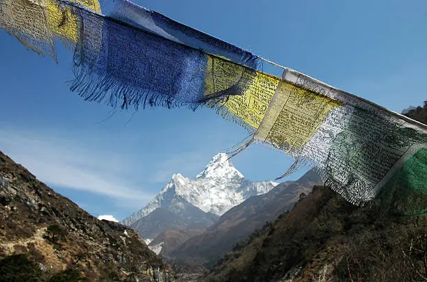 Tibetan prayer flags fluttering in the wind and mount Ama-Dablam in the background. U can see also a trail to Dingboche(Mt Everest Trek)