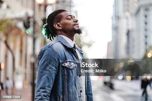 istock Man with his eyes closed stands in the street 1398817559