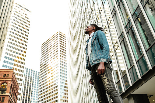 Man standing on the street surrounded by high buildings
