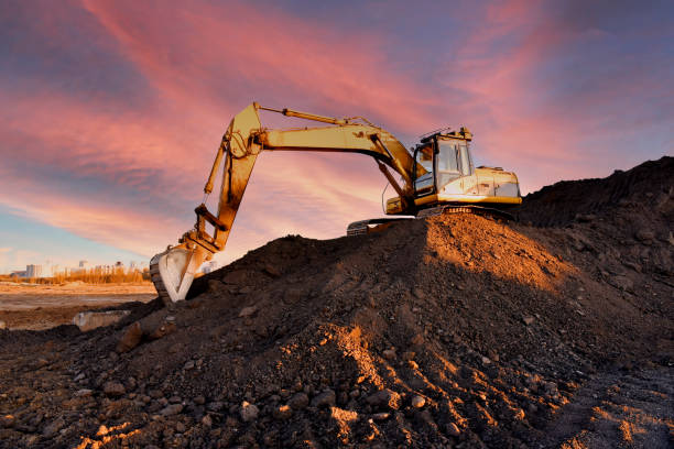 istock Excavator on earthmoving on sunset background. 1398819101