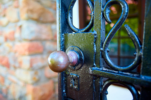 Close-up of a lock with a chain that closes a metal gate during the day