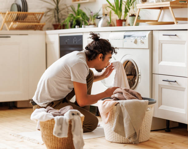 istock Young african american male householder loading washing machine 1398819667